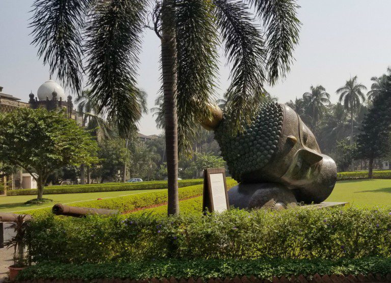 Independent Excursions - photo of large leaning Buddha head on museum grounds