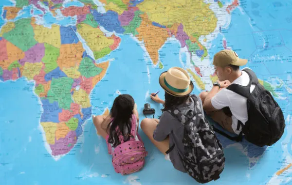 Shore Excursions-Family sitting on large map planning travel