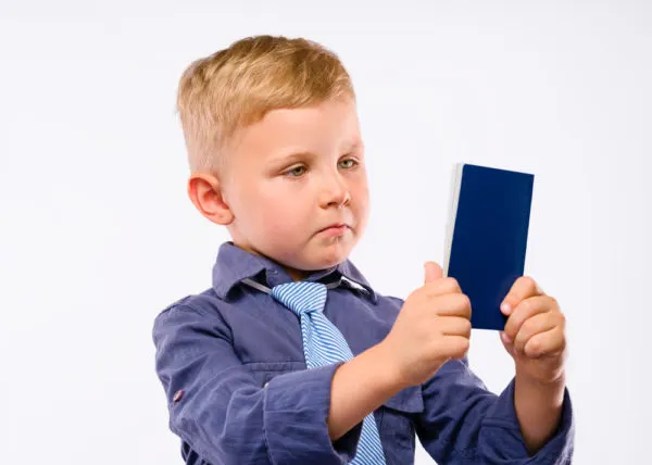 Family Passports - Photo of young boy staring glumly at passport