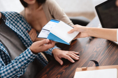cruise specialists - photo of agent handing happy couple travel vouchers