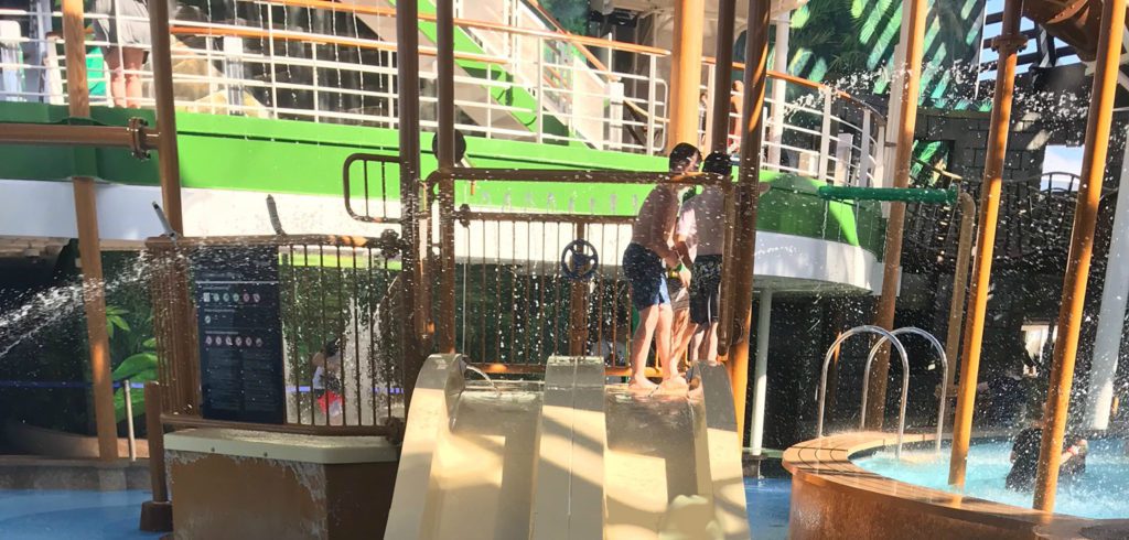 MSC Seaside Review | A child-sized splash zone with mini slides, water cannons, and a nearby pool, set against the ship's upper decks.