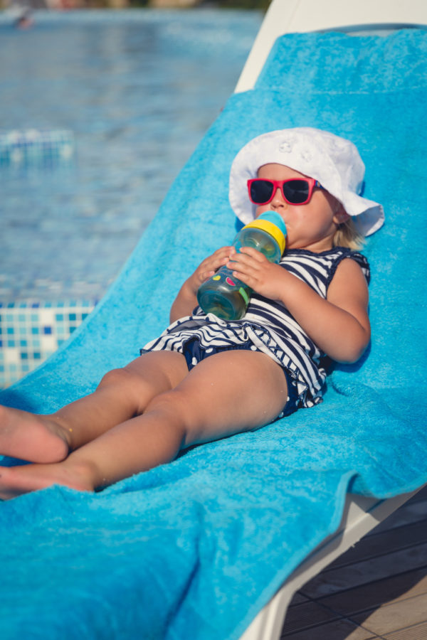Best Family Cruise Ships - Photo of Toddler sipping beverage on lounge chair by pool