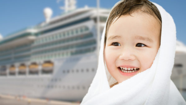 Family Cruise Port Calls | photo of small boy wrapped in towel in front of cruise ship