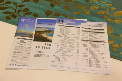 Embarkation Tips | photo of ship newsletters spread on bed