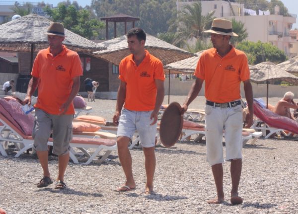 Family Cruise Port Calls | photo of 3 waiters walking on sandy beach