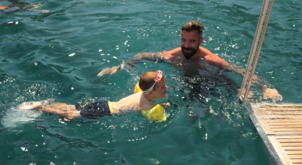 Family Cruise Port Calls | photo of father and son swimming in goggles and arm floats