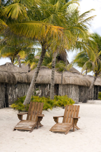Things to do in Cozumel port | photo of beach chairs in front of huts and palm trees