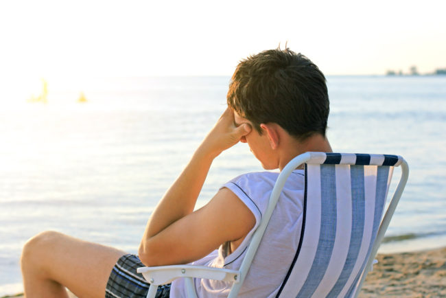Avoid Cruise Mistakes | photo of sad young man on beach