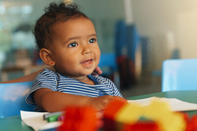 cruises with childcare | photo ofHappy baby playing with toy blocks.