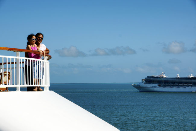 Plan A Cruise | Photo of mother and daughter standing at cruise deck railing enjoying the view.