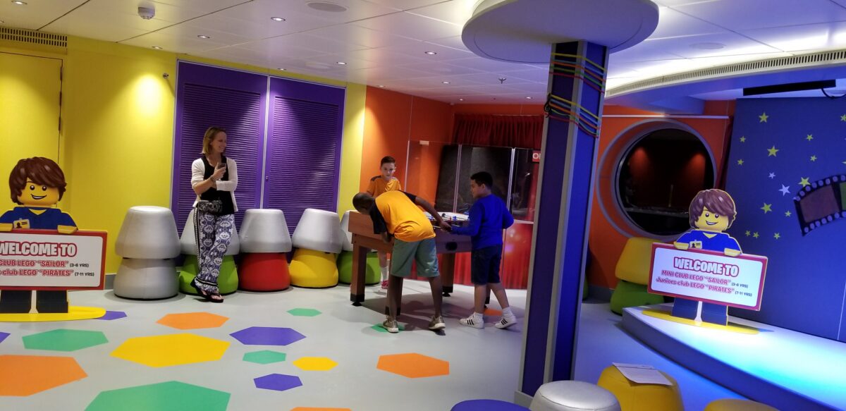 MSC Seaside Review | Photo of 3 boys playing foosball in MSC Seaside kids' club while parent observes.