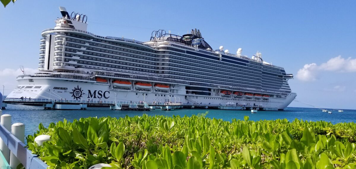 MSC Seaside Review | MSC Seaside docked at a pier, its rooftop waterpark structure visible against a clear blue sky.