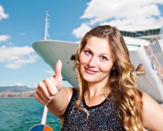 Cruise Accessories | photo of woman in front of cruise ship with thumbs up approval