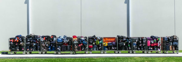 Cruise Carry On Essentials | photo of row of luggage trolleys filled with onboarding cruise luggage