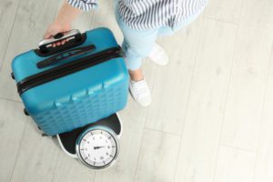 Photo of woman weighing suitcase
