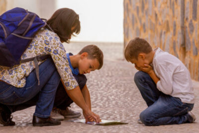 photo of mom and two kids looking for directions in foreign city
