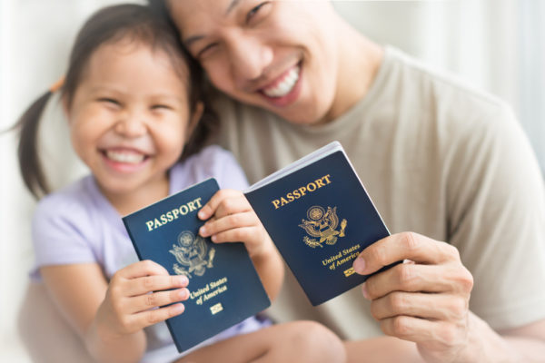Flying with Young Children | photo of dad and preschooler holding new passports.