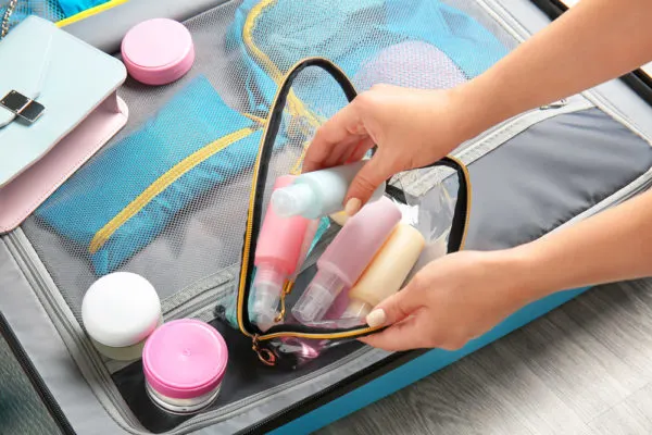 Do Cruise Ships Provide Shampoo | photo of woman's hands packing toiletries for suitcase