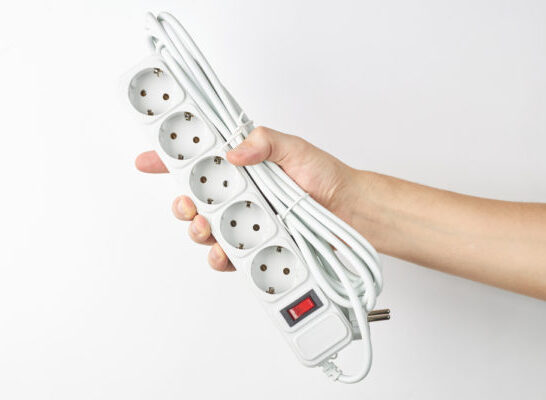 Why No Surge Protector On Cruise Ship | person holds empty white power cord strip. outer space. isolated on white background