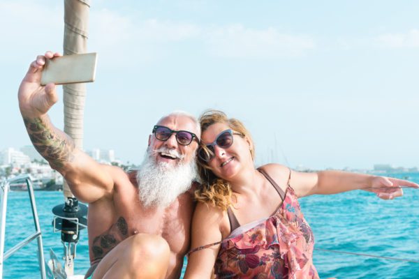 How To Plan A Surprise Anniversary Trip For Your Parents | photo of happy senior couple celebrating on the ocean