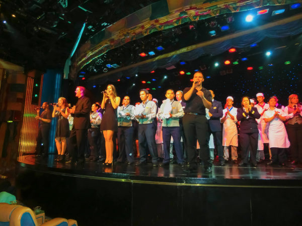 How Much Does A Cruise Director Make | photo of members of Entertainment Department on stage at cruise opening