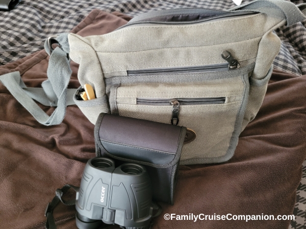 Best Binoculars for Alaska Cruise | photo Occer compact binoculars pictured with their case next to a medium-sized handbag.