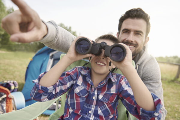 What do the numbers on binoculars mean | photo of father helping child with binoculars