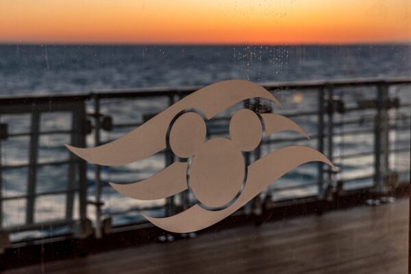 What's Included In A Disney Cruise | photo of large modern Disney logo mounted on metal ship guardrails.