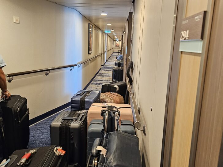 Photo of luggage for numerous passengers lined up down the hallway.