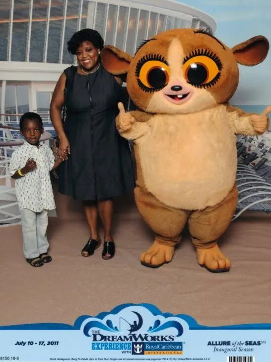 Vintage photo of mother, young child, and Dreamworks character Mort on Royal Caribbean ship.