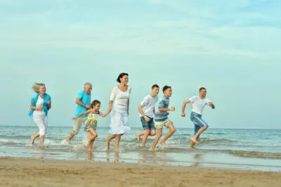 Family Reunion Cruise | photo of multigenerational group racing down the beach with glee.