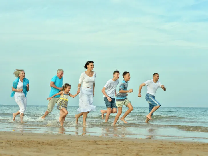 Family Reunion Cruise | photo of multigenerational group racing down the beach with glee.