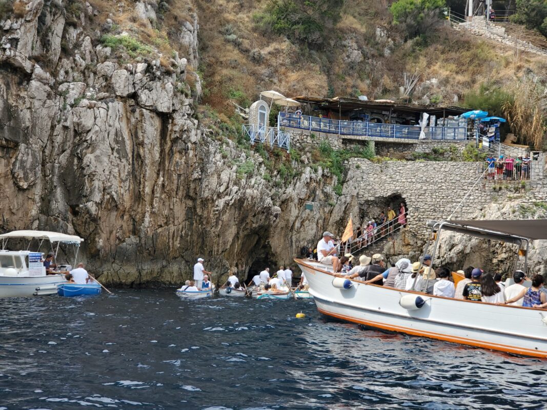Photo of bottleneck of rowboats outside entrance to the Blue Grotto.