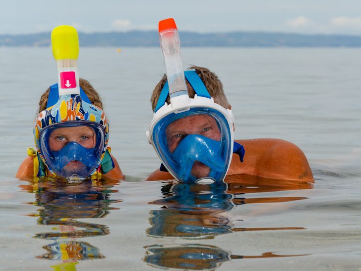 Photo of adult and child wearing full-face snorkeling masks.