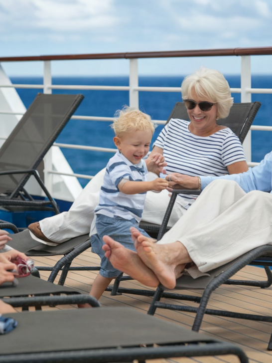 Cruise the Caribbean | grandparents lounging on deck of cruise ship with their kids and grandchild