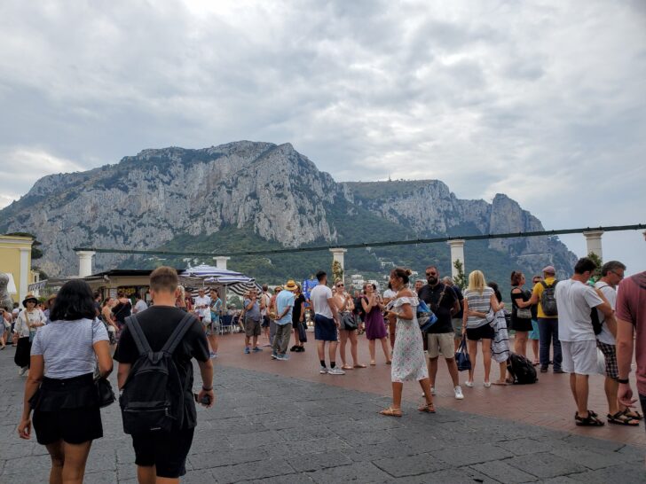 Best Time for a Mediterranean Cruise | photo of tourists gathered at a scenic viewpoint in Capri, Italy, with the island's iconic cliffs in the background.