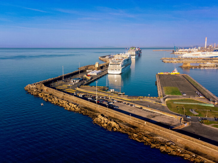 Civitavecchia, the port city near Rome, featuring large cruise ships docked and an expansive pier extending into the Mediterranean Sea.