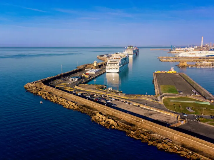 Civitavecchia, the port city near Rome, featuring large cruise ships docked and an expansive pier extending into the Mediterranean Sea.