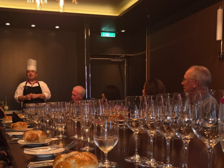 Photo of head chef greeting diners during a Chef's Table experience on a Royal Caribbean cruise ship