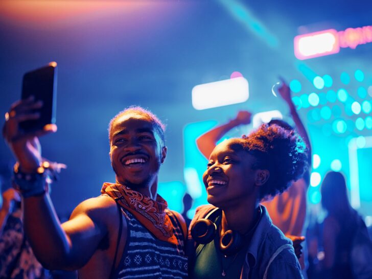 Cruises With Overnight Stays | couple enjoying festival nightlife and taking selfie dancing