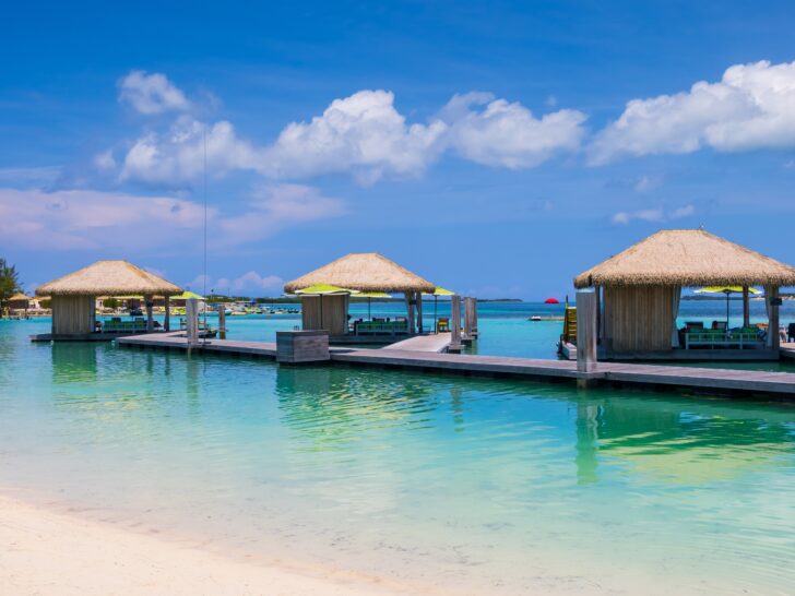 Photo of three adjacent overwater beach cabanas at a Caribbean resort. 