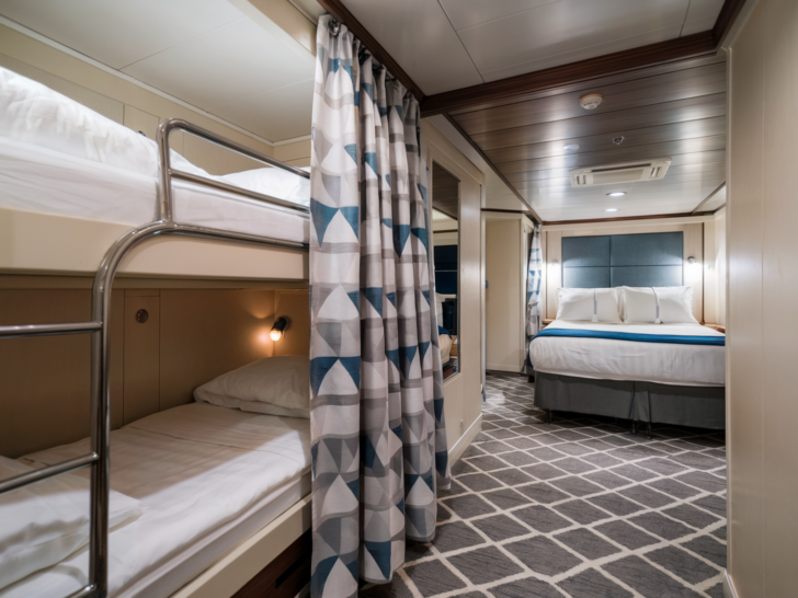 Photo of Inside cruise cabin with a bunk bed setup and queen bed, ideal for families.