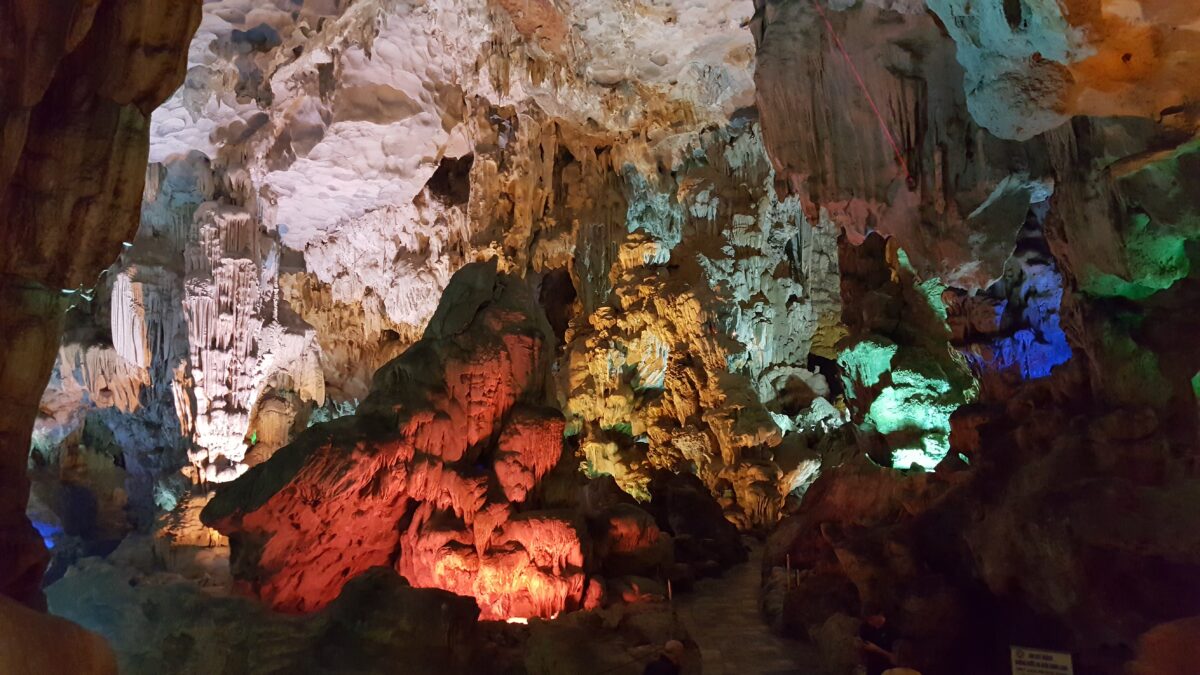 Colorfully lit stalactites and stalagmites inside Sung Sot Cave in Halong Bay, Vietnam, showcasing one of the unique cruise destinations known for its breathtaking limestone formations.