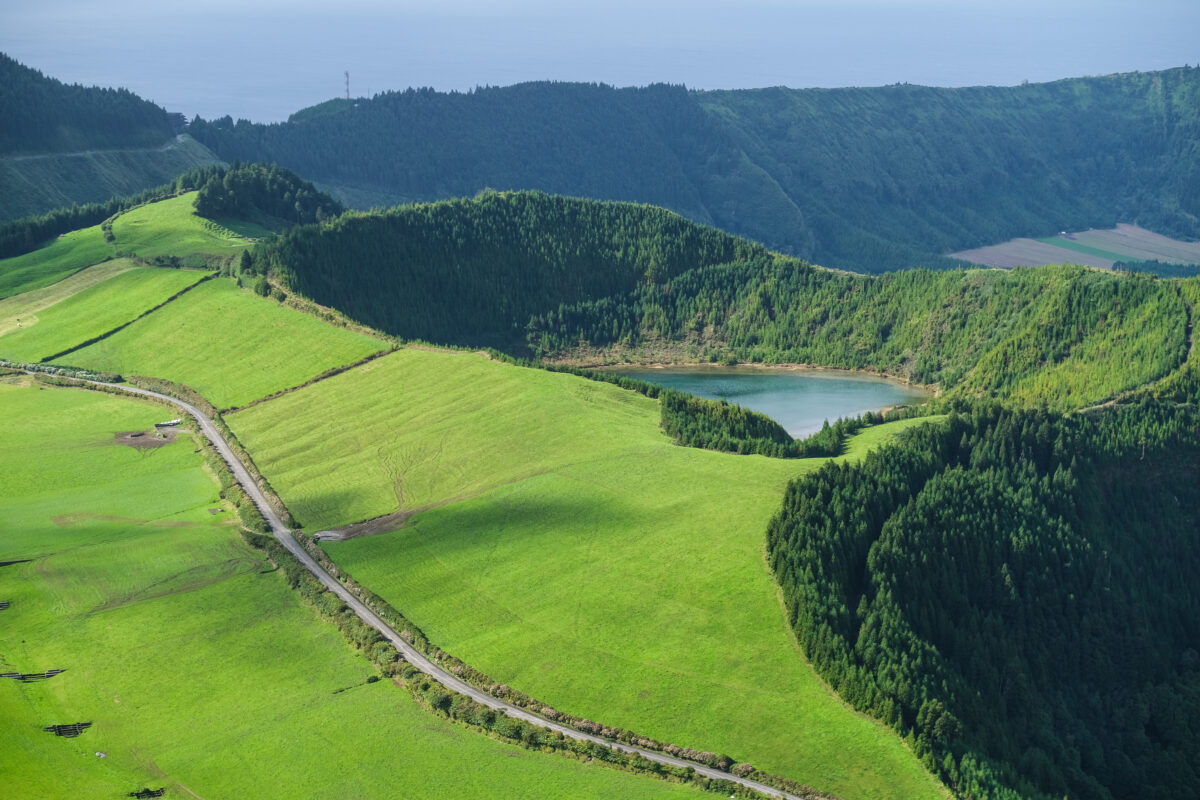 Aerial view of the lush green hills and volcanic lake of the Azores, a beautiful stop for travelers seeking unique cruise destinations and natural adventures.