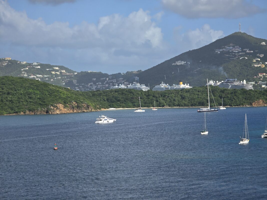 Bahamas vs Caribbean Spring Break Cruises | A scenic view of Charlotte Amalie, St. Thomas, featuring multiple cruise ships docked near the coastline. The deep blue waters and clear skies highlight the tropical beauty of this Caribbean cruise destination.