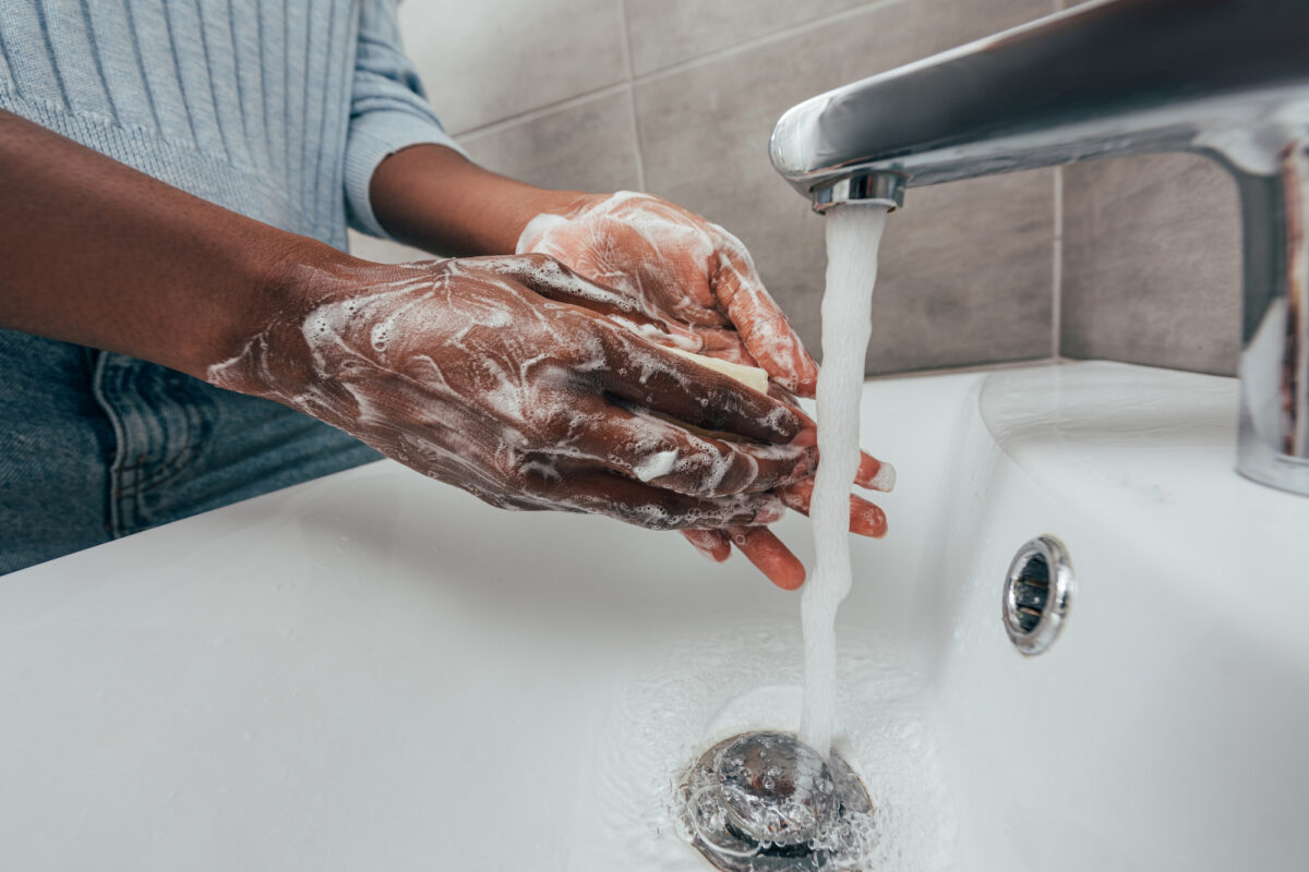 A person scrubbing hands thoroughly with soap and water, a key measure in cruise ship health and safety protocols.