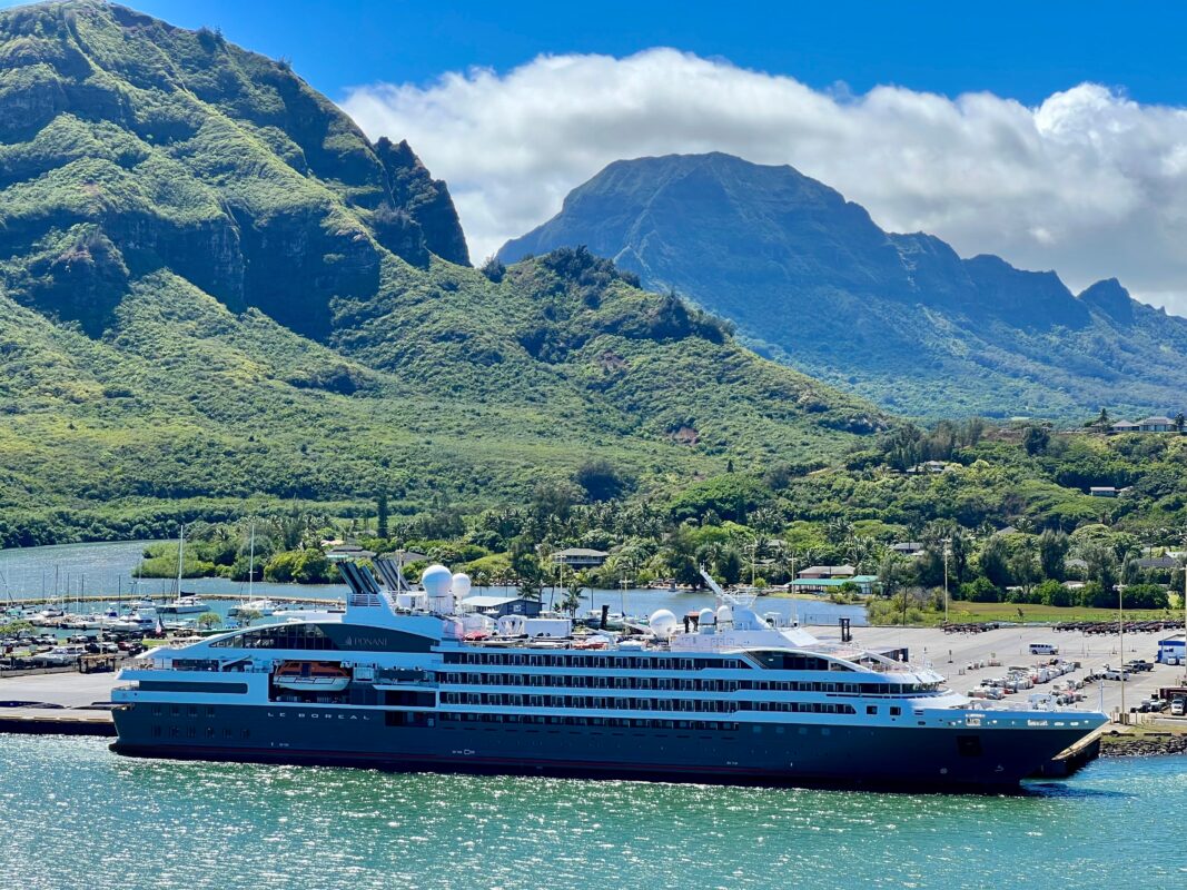 The Le Boréal at port in Lihue, Kauai, with the island’s lush, mountainous landscape creating a stunning Hawaiian cruise setting.