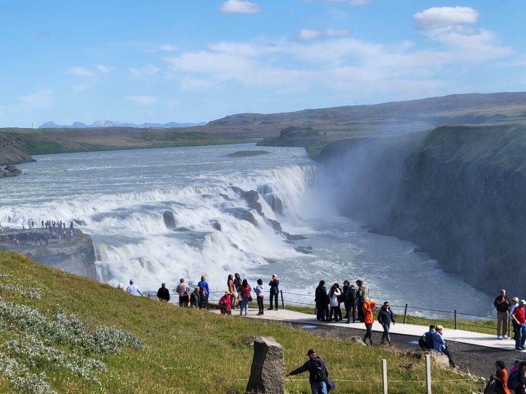 Visitors admire Gullfoss Waterfall, a common stop for both cruise line excursions and budget-friendly independent tours.