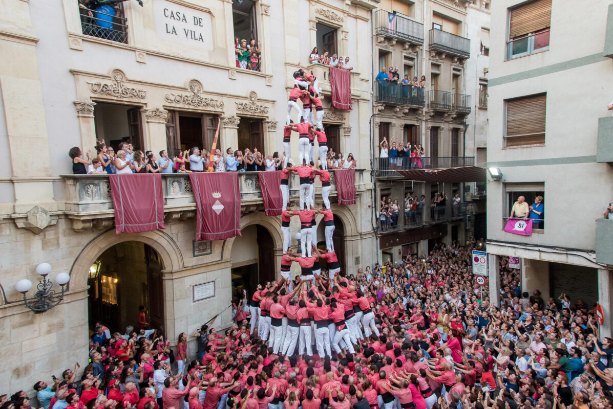 A traditional castell reaches high above the cheering spectators in Valls, showcasing Catalonia’s unique heritage during this Mediterranean festival.