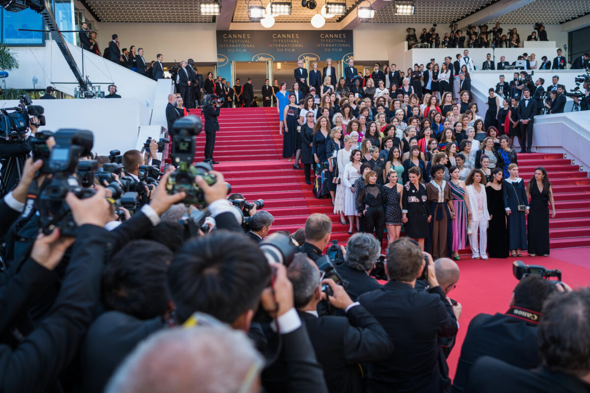 Crowds of photographers surround film industry stars on the grand staircase at the Cannes Film Festival, a highlight of Mediterranean festivals known for its luxury and cinematic prestige.